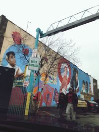 Graffiti on wall in city against sky