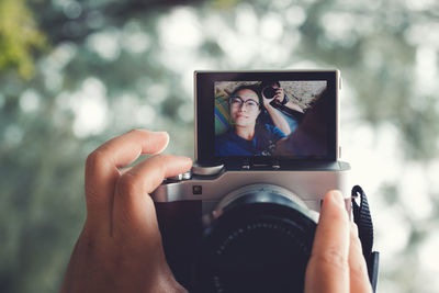 Close-up of camera photographing couple lying on field