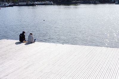 Rear view of couple sitting on promenade