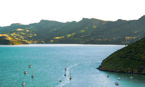 Scenic view of sea by mountains against sky