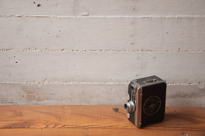 Close-up of vintage camera on table against wall