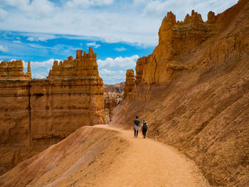 People on rock formations in a desert