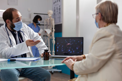 Portrait of doctor and patient discussing at clinic