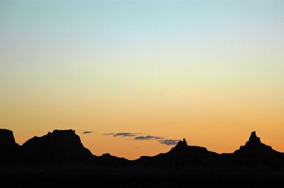 Scenic view of silhouette mountains against clear sky at sunset