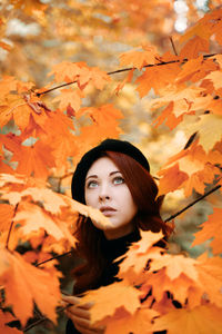 Portrait of young woman with autumn leaves