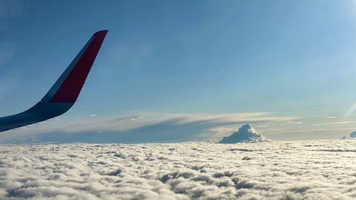 Airplane flying over snowcapped mountains against sky