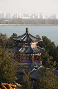 Traditional building by river against sky in city