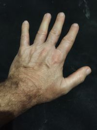 Close-up of human hand over black background