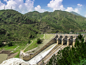 Scenic view of dam and mountains against sky