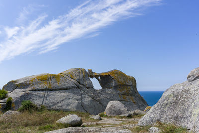 Low angle view of rock formation against sky, pedra da campá, in cíes islands 