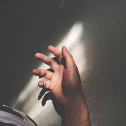 Cropped hand against wall
