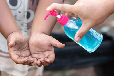 Close-up of hands holding bottle