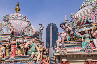 Low angle view of statue against buildings