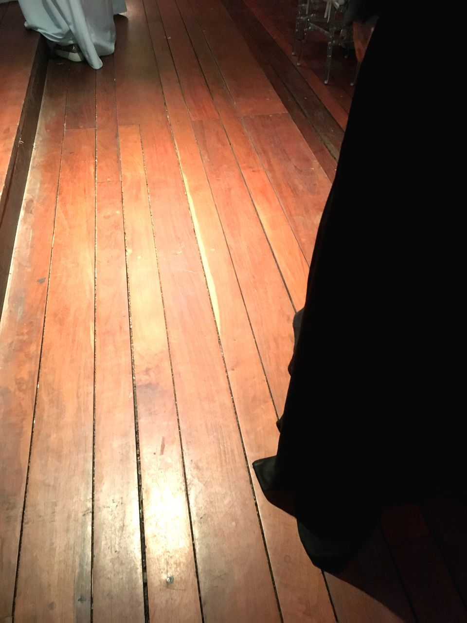 HIGH ANGLE VIEW OF PERSON RELAXING ON HARDWOOD FLOOR