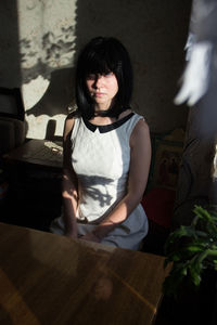 Portrait of a smiling young woman sitting at home