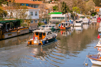 Sailboats moored on canal in city