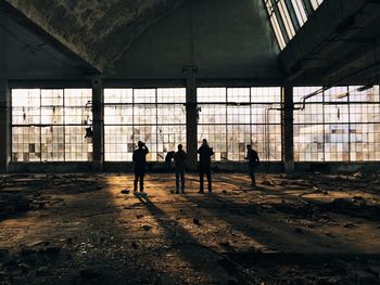 Rear view of men standing in abandoned building