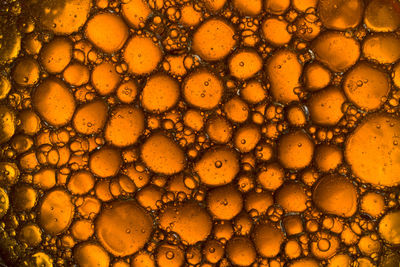 Abstract background of yellow oil drops on water