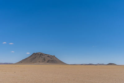 Scenic view of desert against blue sky