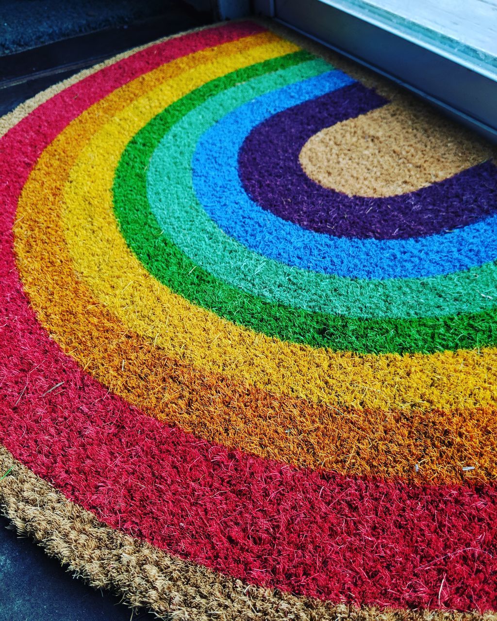 HIGH ANGLE VIEW OF MULTI COLORED RUG ON CARPET