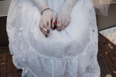 High angle view of woman holding white dress