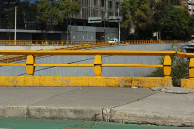 Yellow road by railing in city