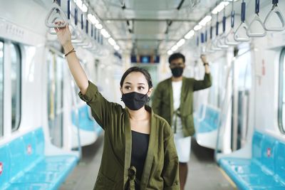 Portrait of young woman standing on railway station