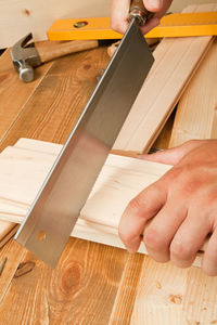 Close-up of carpenter cutting wood