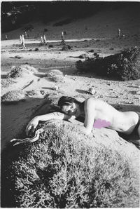 Portrait of young woman lying on sand at beach