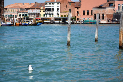 Boats in sea against buildings in city