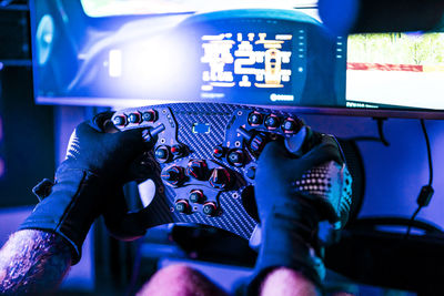 Male gamer playing game on computer through controller at studio