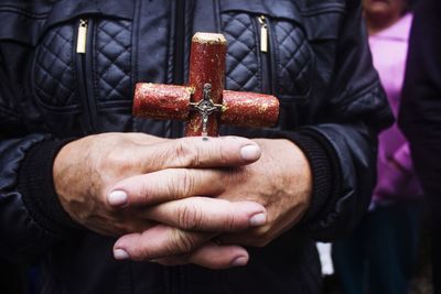 Close-up of man holding religious cross