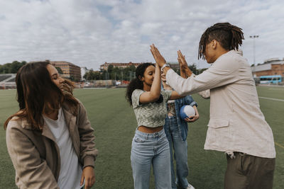 Happy teenagers giving each other high fives