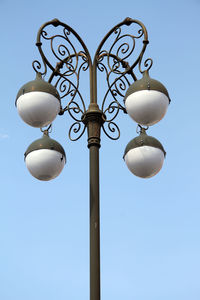 Low angle view of street light against blue sky