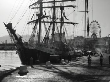 Sailboats moored at harbor against sky