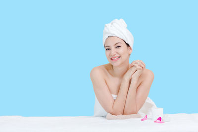 Portrait of a smiling young woman against blue background