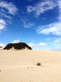 Scenic view of sand dunes against sky