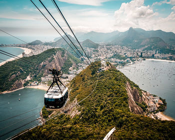 Overhead cable car over mountains against sky