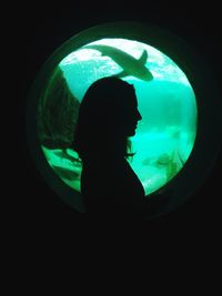 Side view of silhouette woman standing in dark