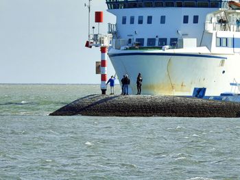 People on sea against clear sky