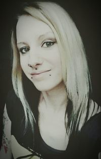 Portrait of young woman against black background