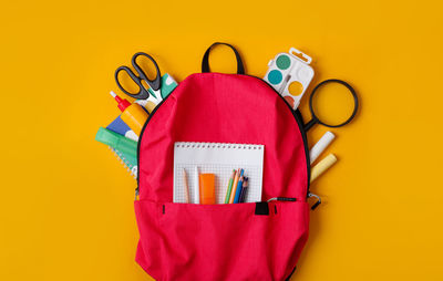 High angle view of personal accessories on yellow background