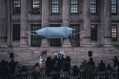 Group of people against buildings in city