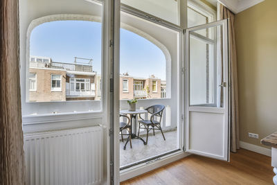 Empty chairs and table by window at home