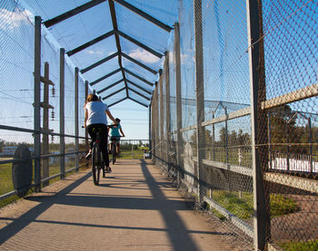 Rear view of man riding bicycle against sky