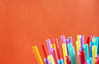 Close-up of multi colored pencils against pink background