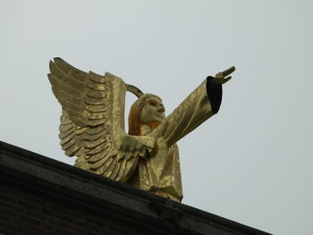 Low angle view of angel statue against clear sky