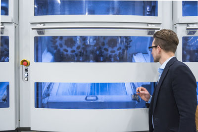 Man looking at machine in factory shop floor