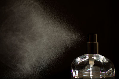 Close-up of glass bottle against black background