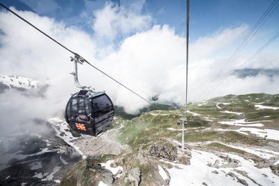 Ski lift over snowcapped mountains against sky